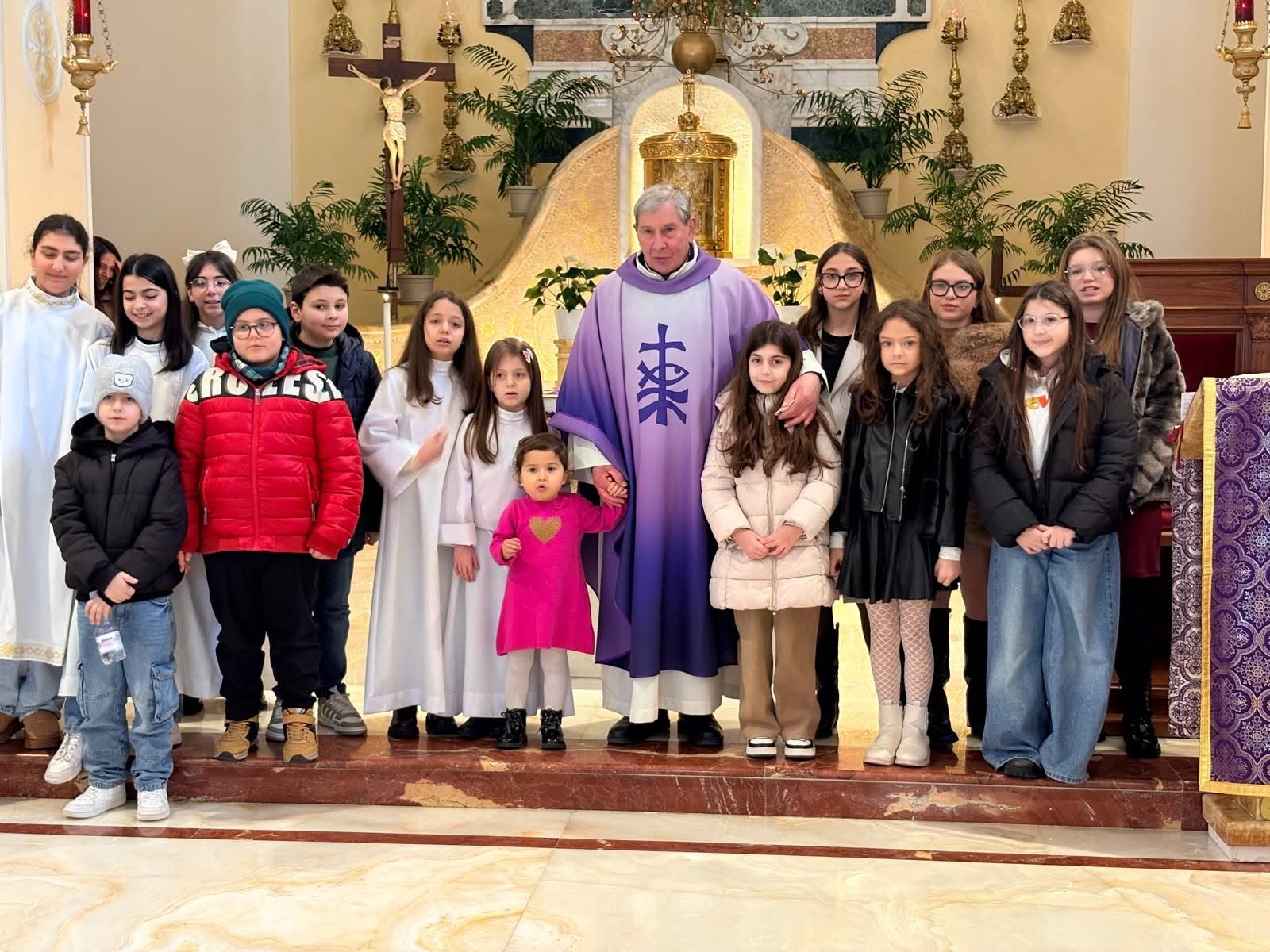 Il parroco con i bambini durante la catechesi
